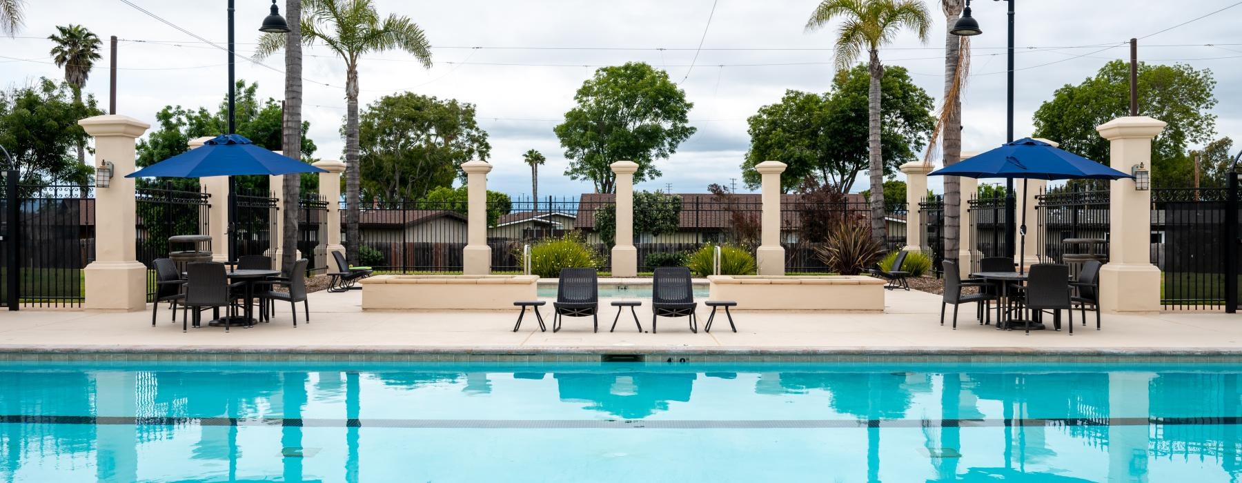 a pool with chairs and umbrellas by it