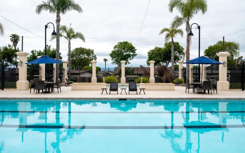 a pool with chairs and umbrellas by it