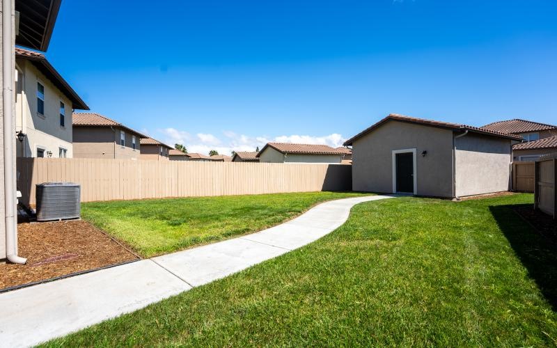 a backyard with a fence and a brick wall