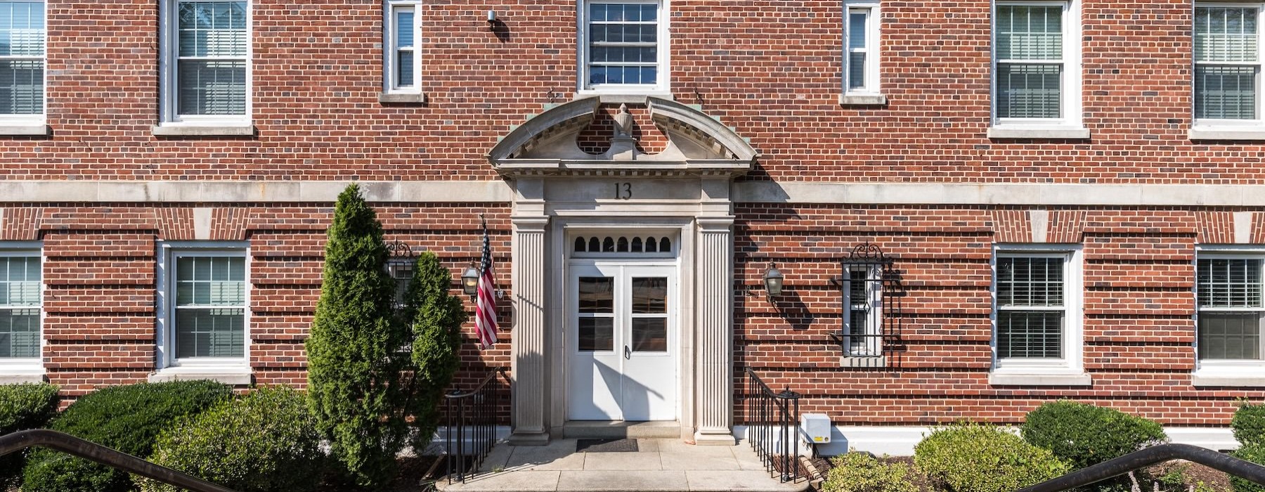 a brick building with a path leading to a white door