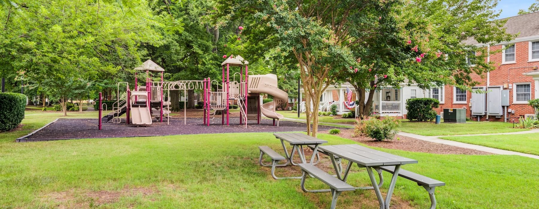 a playground with a slide and a picnic tables next to it