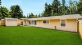 a fenced-in home with a grassy backyard