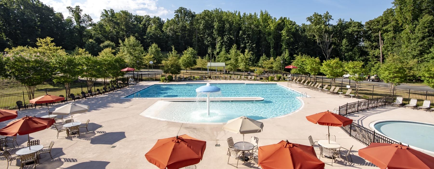 a pool with umbrellas and chairs next to it