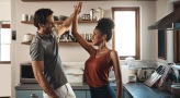 a man and a woman dance in well lit kitchen