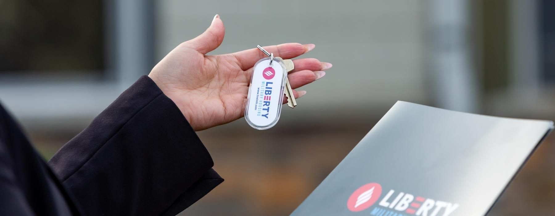 a person holding a key and a folder