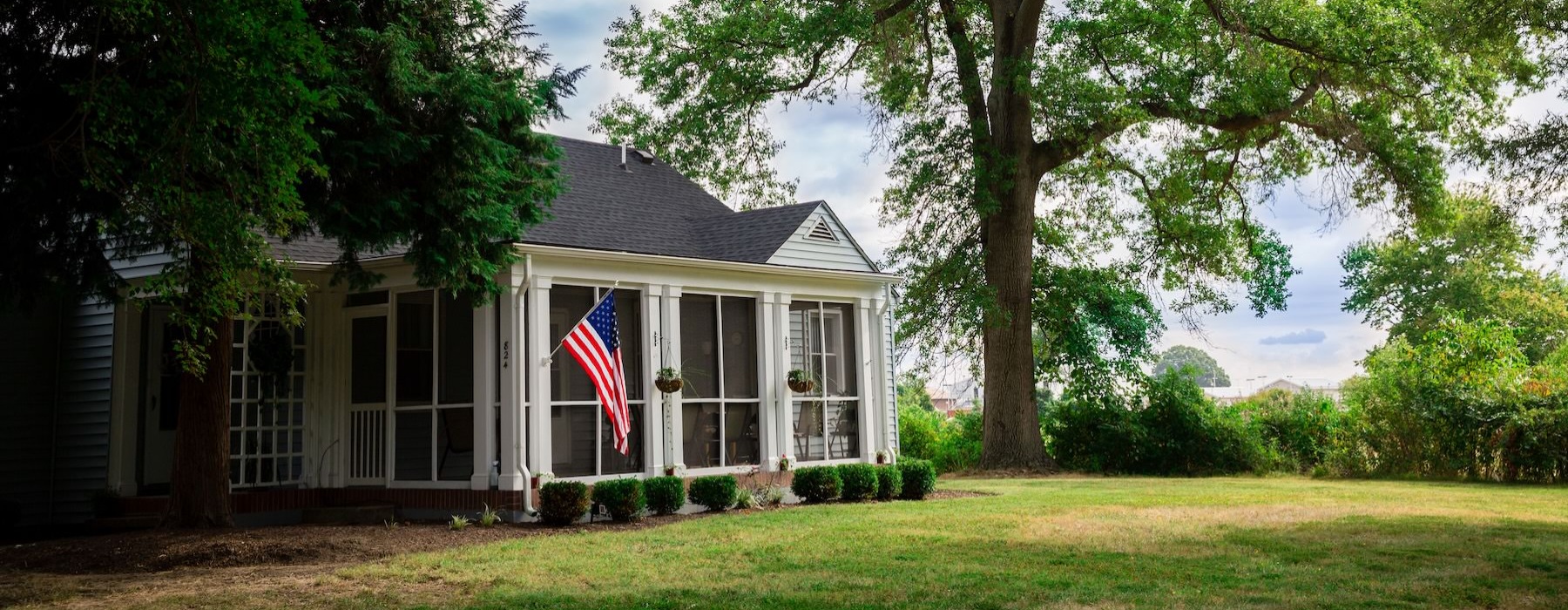 a house with an American flag amongst trees