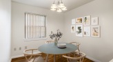 Dining room with dining table, four chairs, and flowers with vase on table