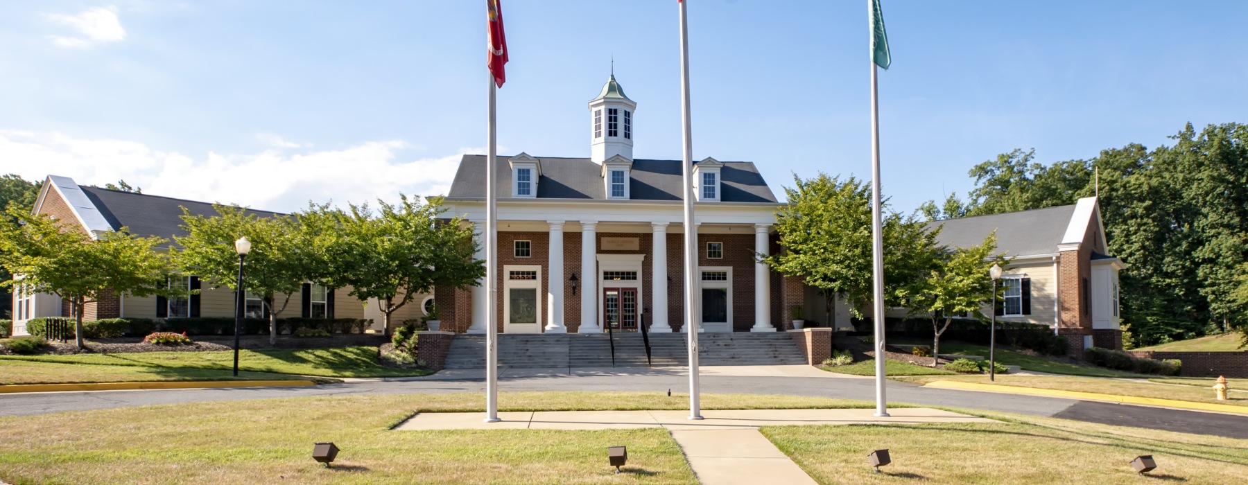 Exterior of a building with grass and flag poles in front