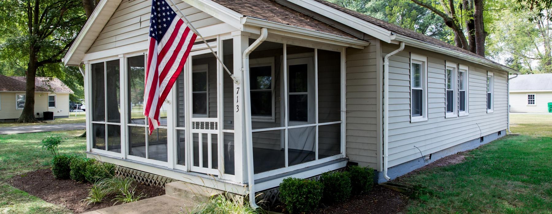 a small white house with a flag