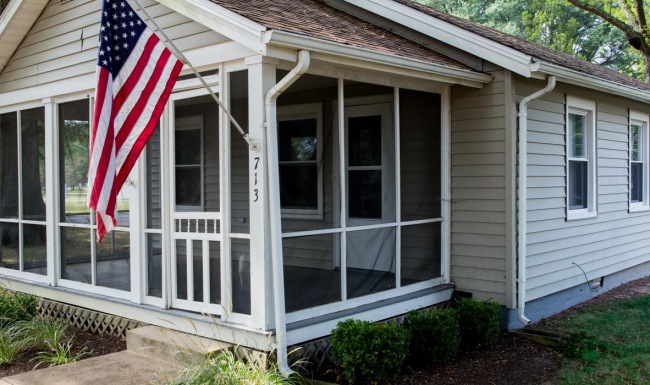 a small white house with a flag