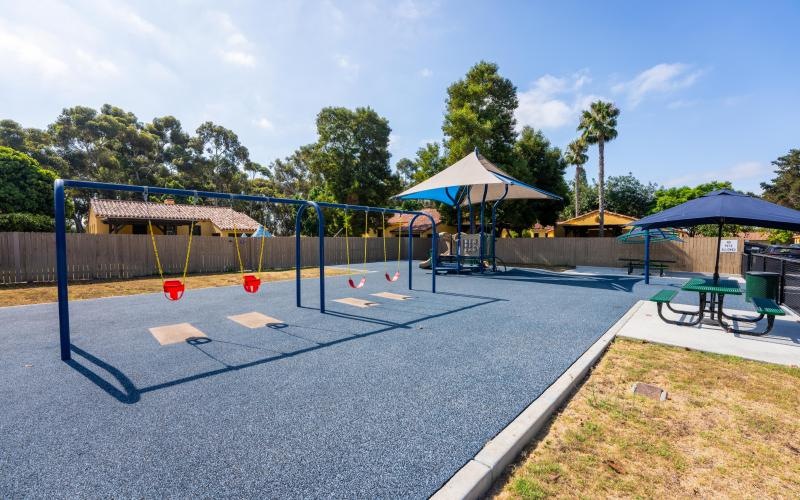 a playground with a trampoline and umbrellas