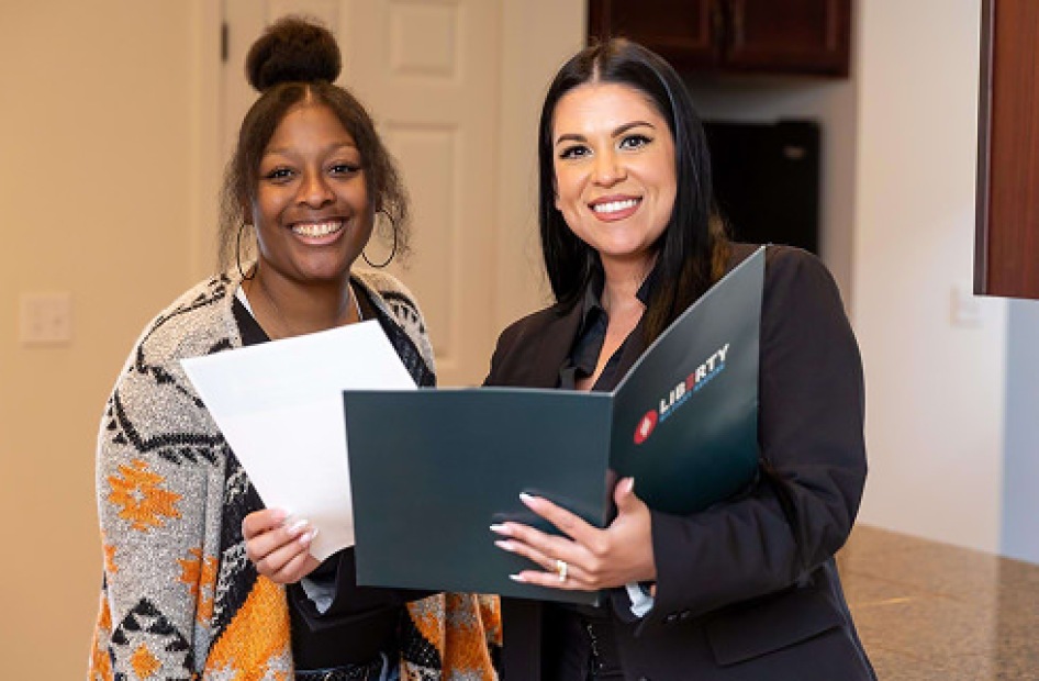 Housing agent presenting lease paperwork to a client.