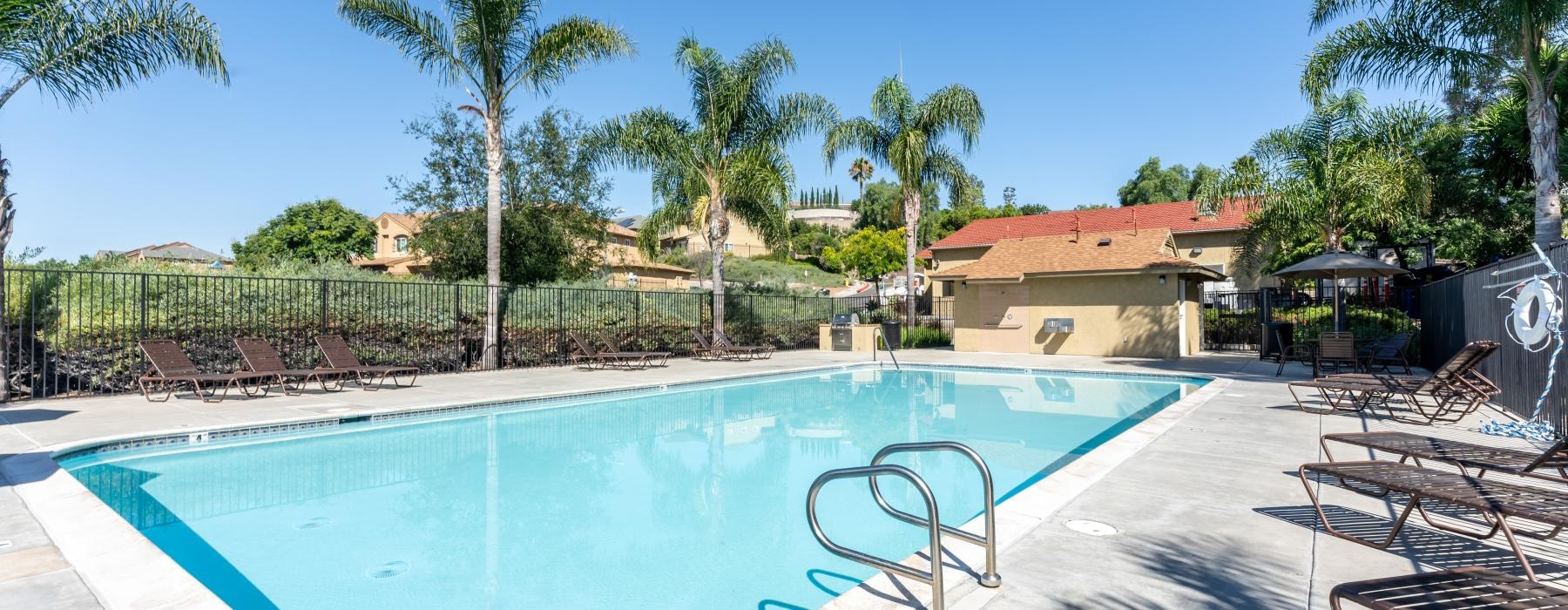 a swimming pool with trees and a fence around it