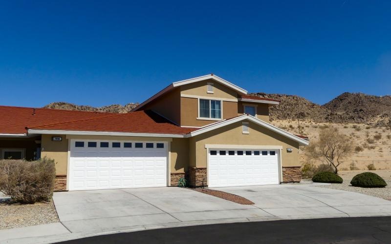 a building with a garage and a hill in the background