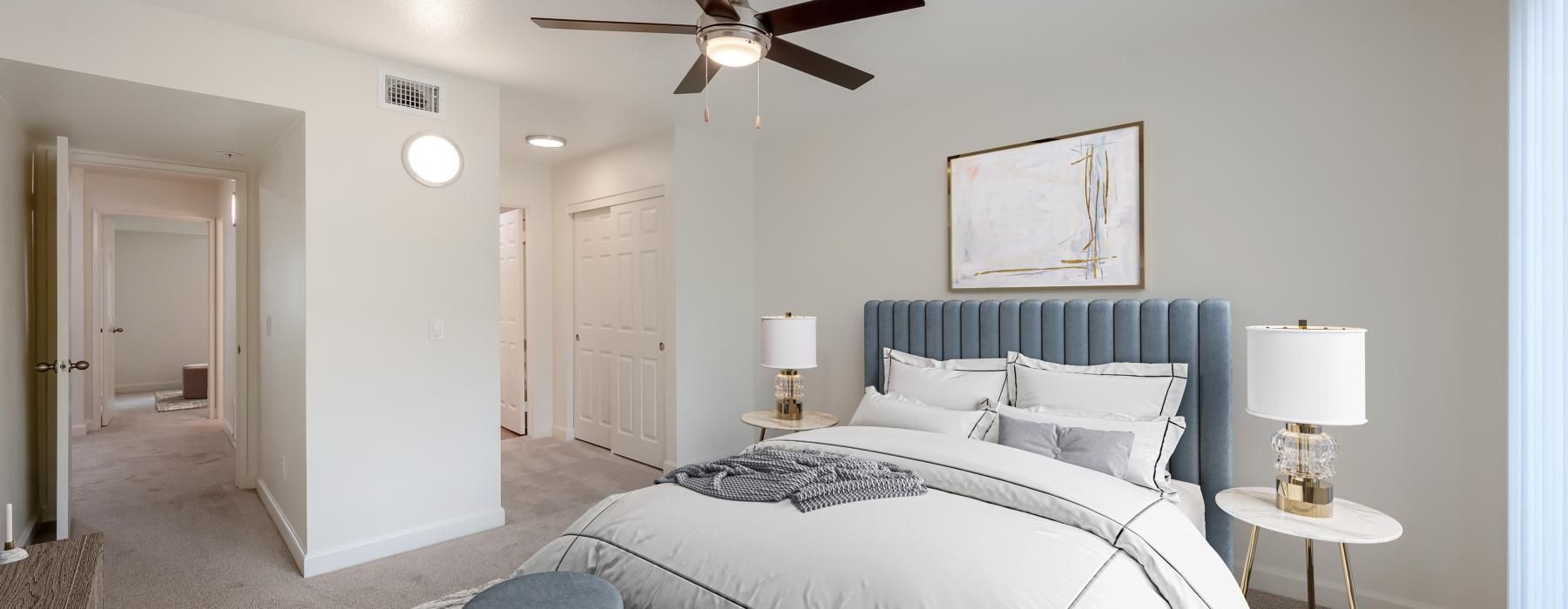 a bedroom with a bed and a fan