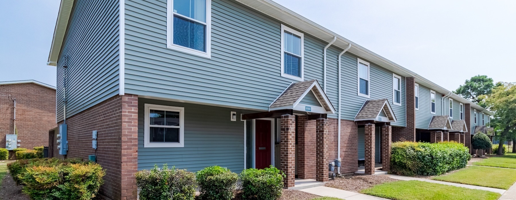 a row of houses with front-yards and walkways