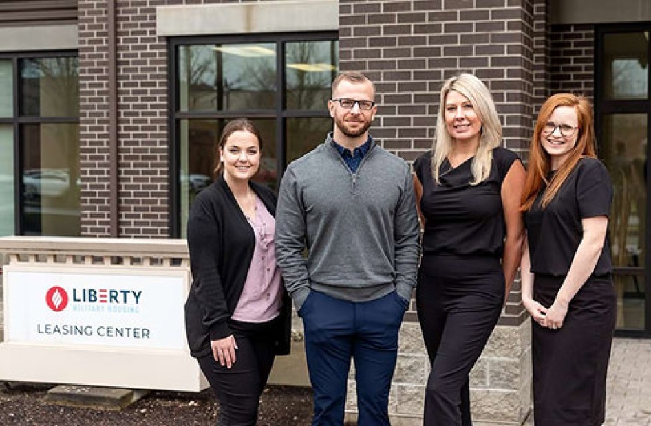 Group portrait of four staff members outside a leasing office.