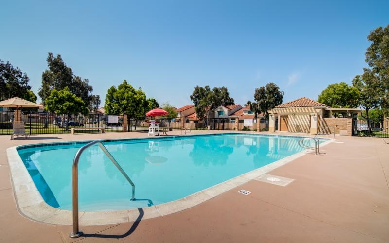 a swimming pool with a deck and umbrellas