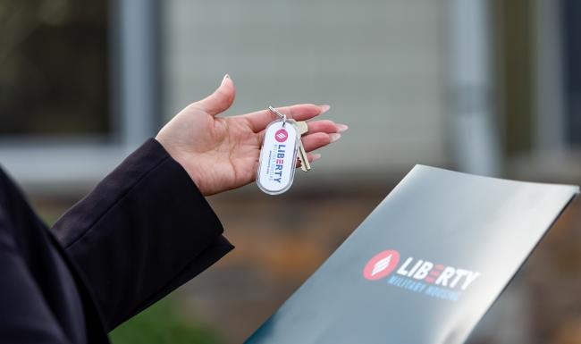 a person holding a key and a folder