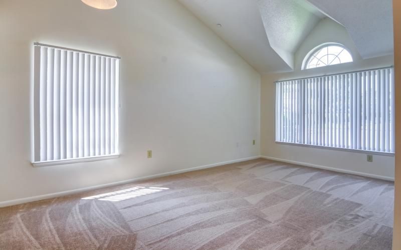 a room with carpet and large windows