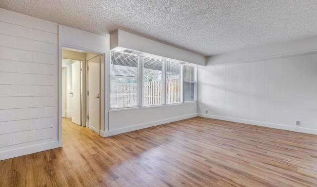 a room with wood-style flooring and windows