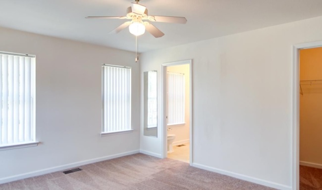 a room with a ceiling fan and a carpet
