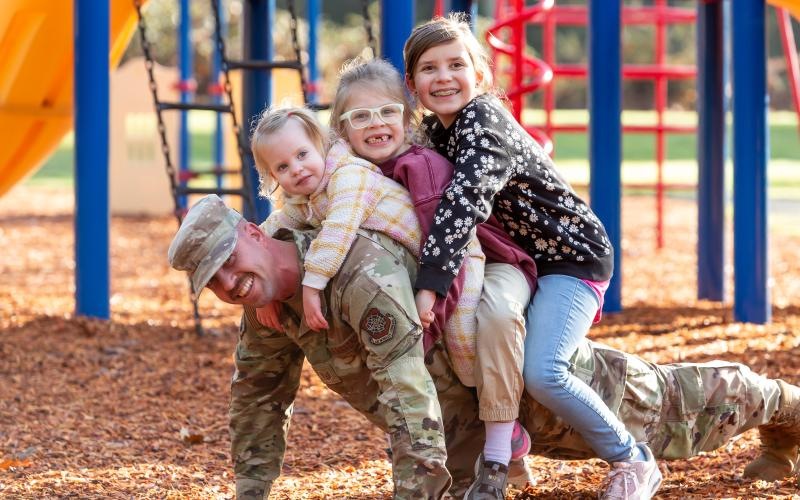a person and two children sitting on a playground