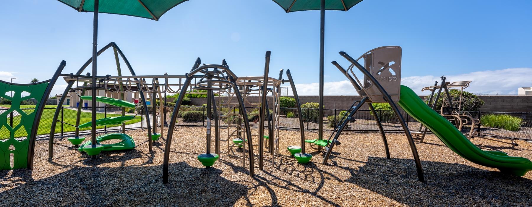 a playground with a slide and umbrella