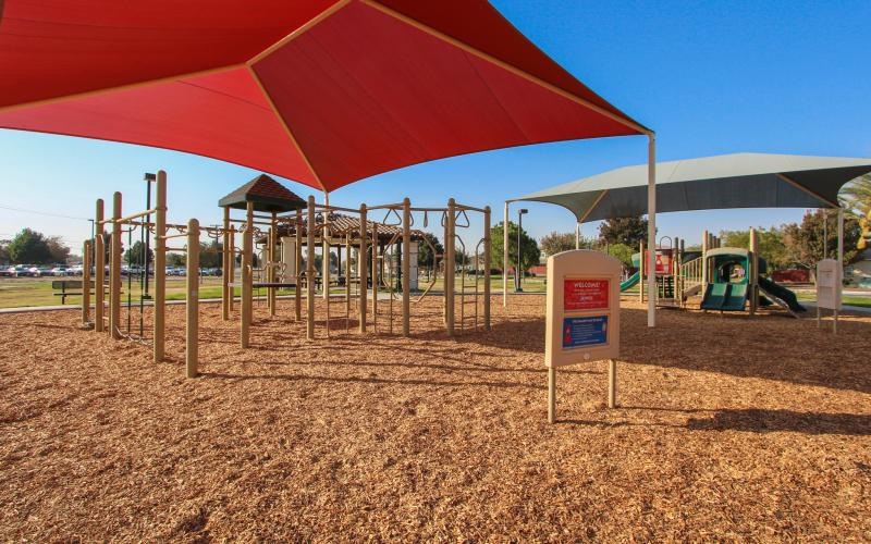 a playground with a red umbrella
