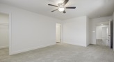 a room with a ceiling fan and white walls