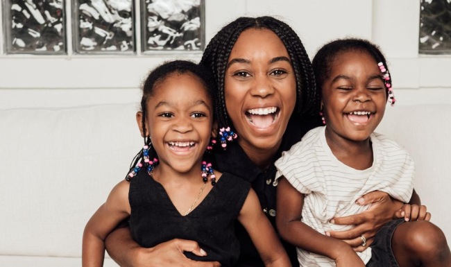a woman sitting on a couch with two kids