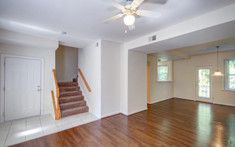 a large empty room with a wood floor and a ceiling fan
