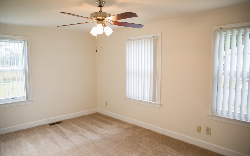 bedroom with carpet ceiling fan and windows
