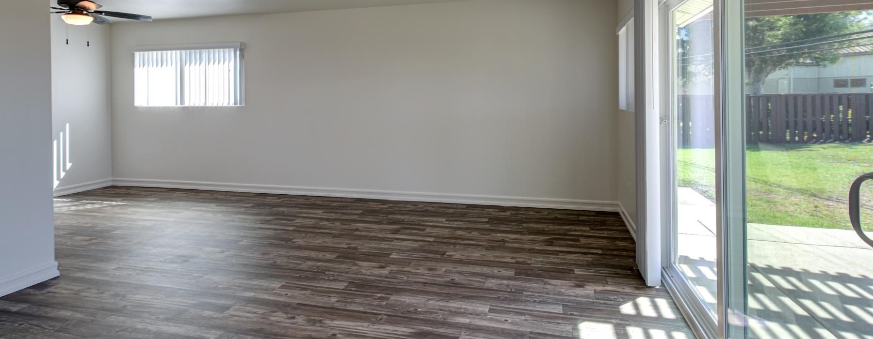a room with a wood floor and a ceiling fan and a wood floor
