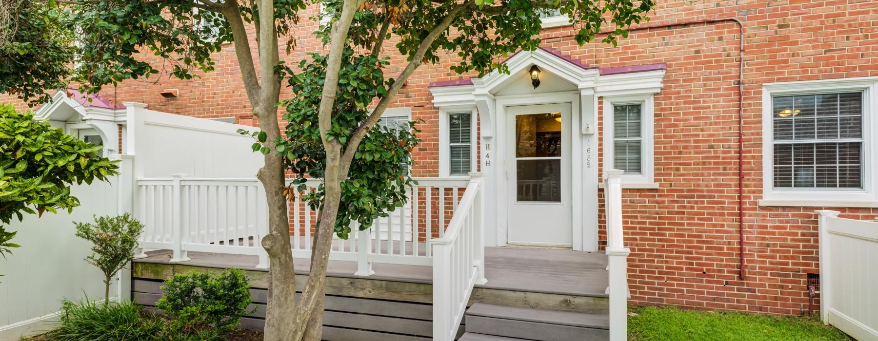 a brick house with a tree in front of it
