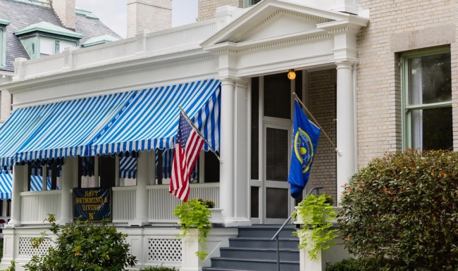 a building with a blue awning and a flag on the roof