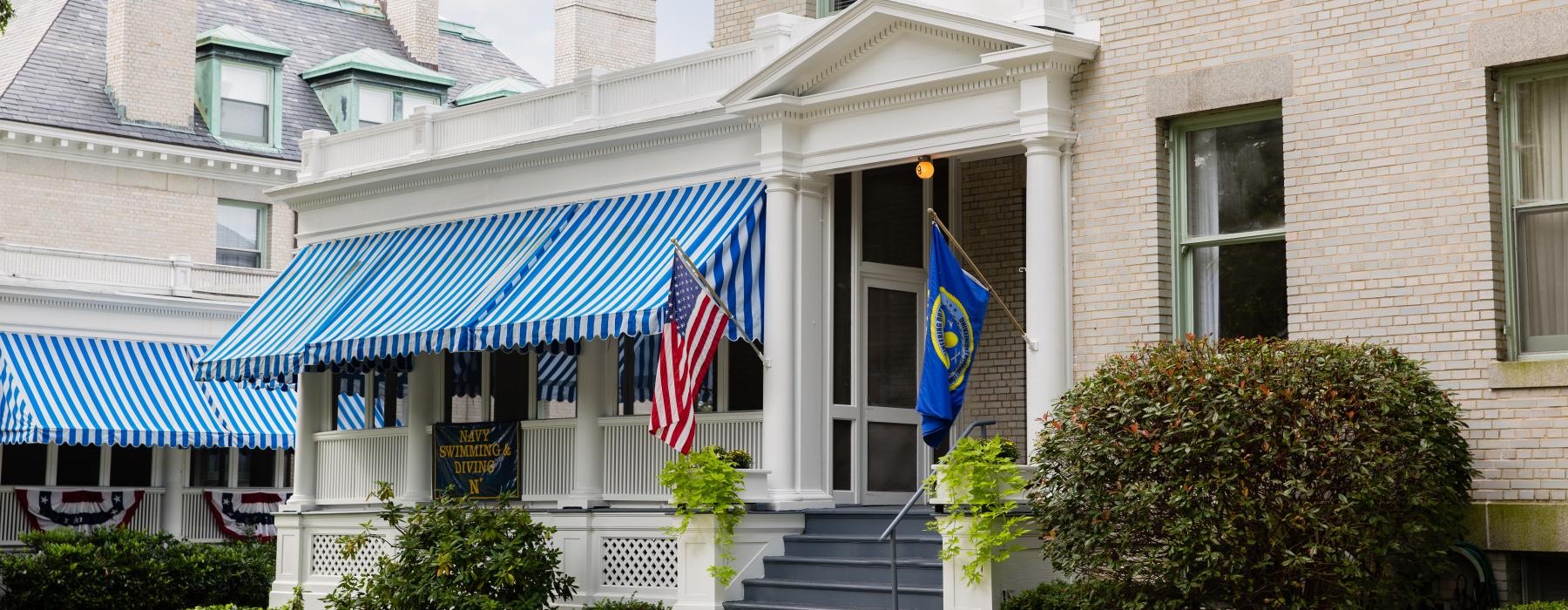 a building with a blue awning and a flag on the roof
