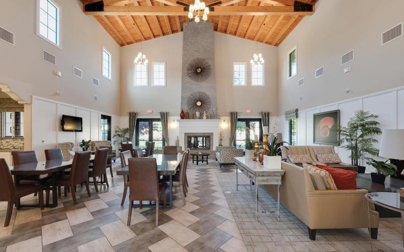 a large club room with a large chandelier and a couch