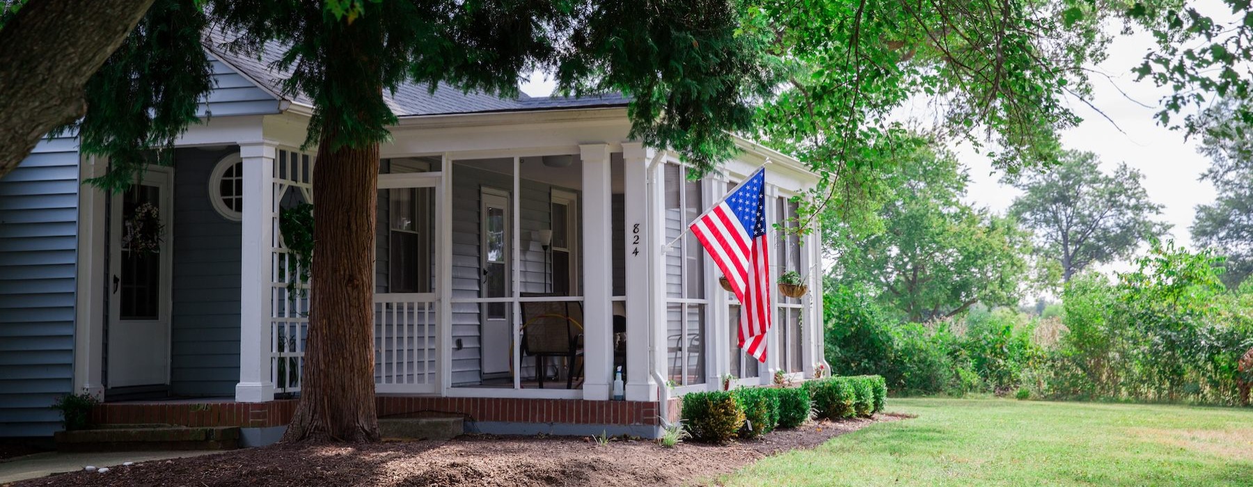 a home amongst trees with an American flag