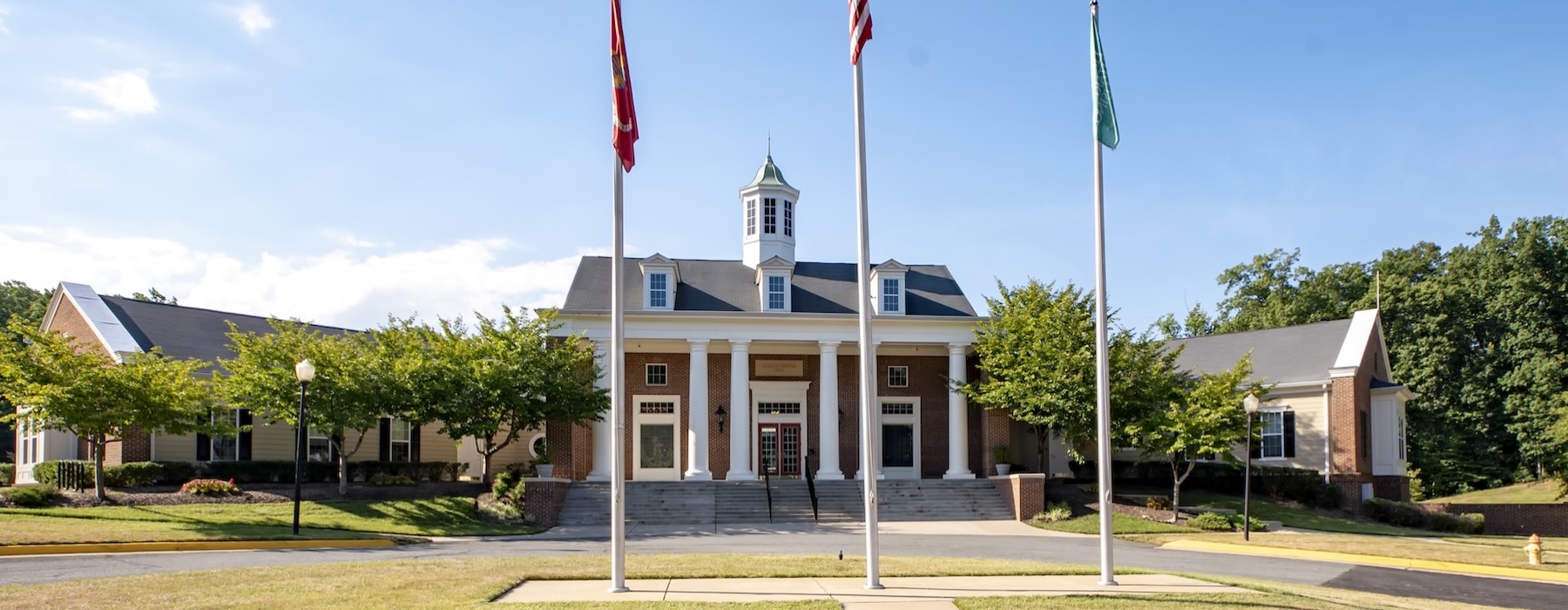 a building with columns and 3 flags out front