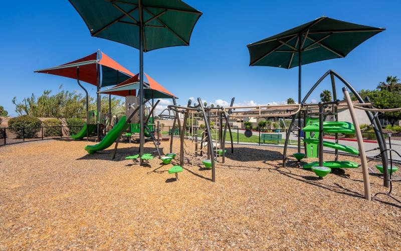 a playground with a slide and umbrella