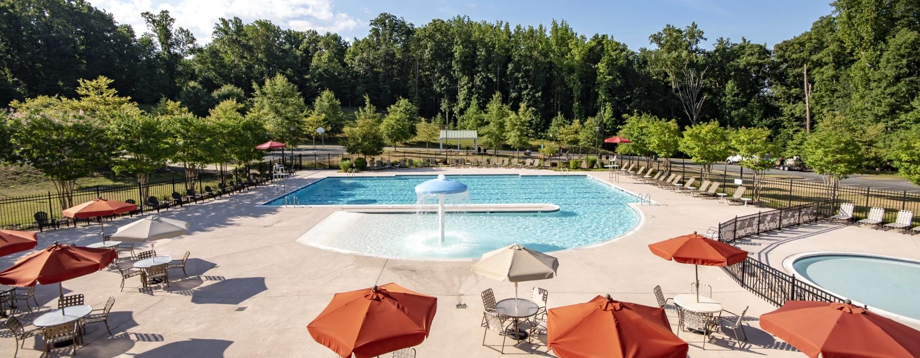 a pool with umbrellas and chairs next to it