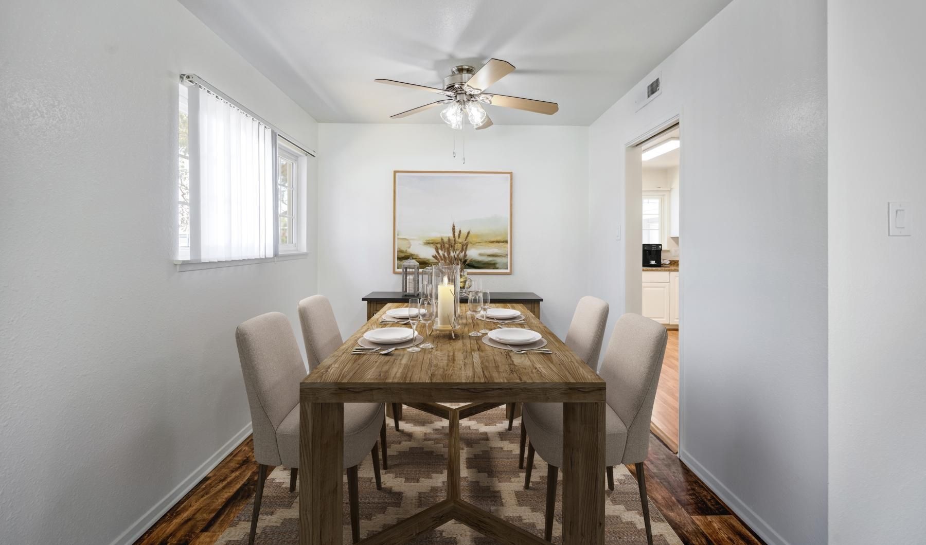 a dining table with a fan above it