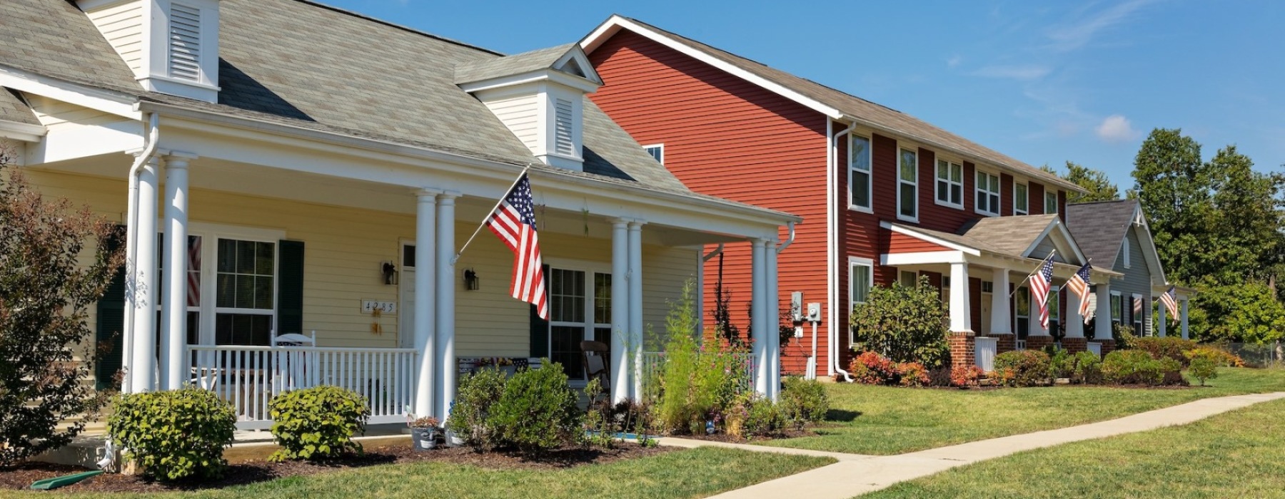 yellow house next to a barn
