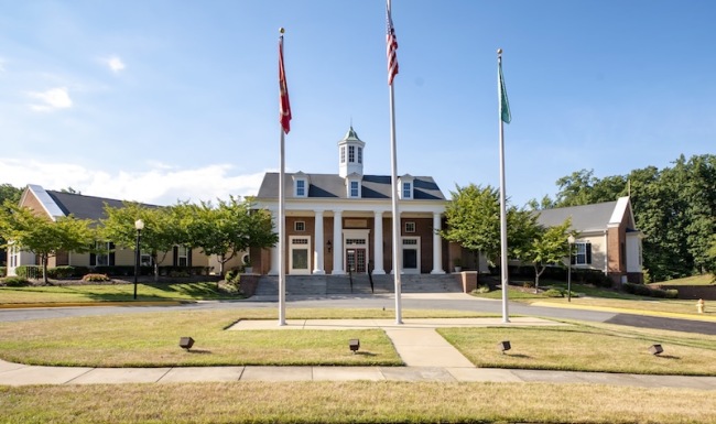 the exterior of a building with three flag poles out front